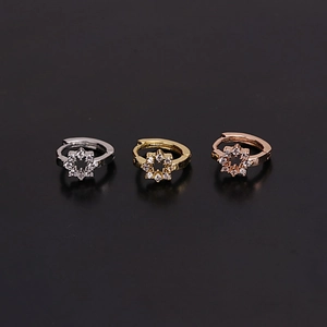 Detailed view of mini floral cartilage earrings in silver, gold, and rose gold plating