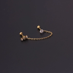 Macro detail of 16G gold chain earring for double piercings with zircon accents