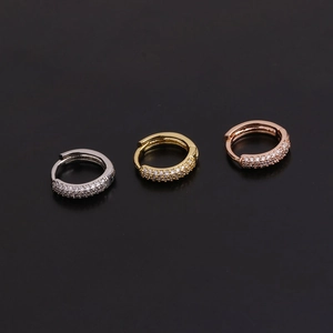 Macro shot of micro-paved zircon huggie earrings in silver, gold, and rose gold finishes