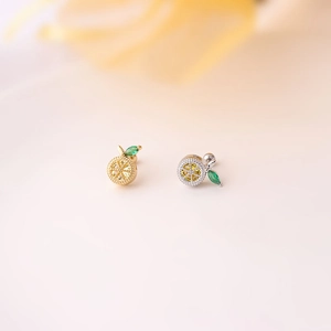 Detail of lemon-shaped fruit stud earrings with yellow cubic zirconia and green leaf stones