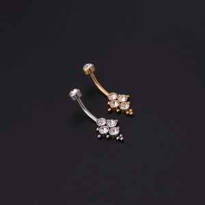Vue détaillée de piercings de nombril argent et or avec motif fleur en zircon brillant
