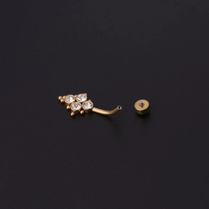 Vue macro d'un piercing nombril doré avec fleur en cristal et tige filetée incurvée