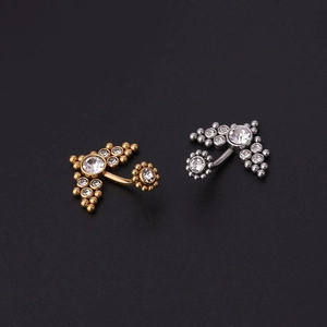 Détail macro de piercings de nombril en or et argent avec des zircons blancs brillants