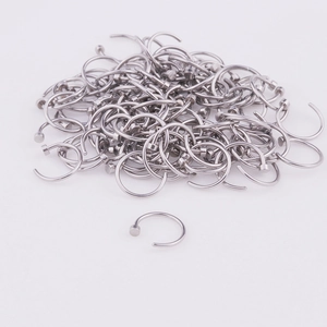 Detailed view of silver 316L stainless steel C-shaped nose ring with flat disc end