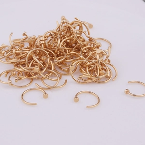 Bulk gold 316L stainless steel open nose rings with flat disc ends on white background