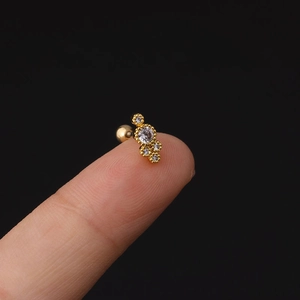 Macro di orecchino barbell dorato con zirconi sulla punta del dito per le dimensioni