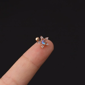 Dettaglio orecchino a stella con opale blu e zirconi bianchi su finitura rosa