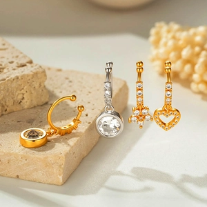 Set of four cubic zirconia navel rings in gold and silver tones with geometric charms