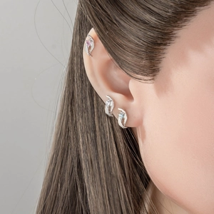 Three-piece silver angel wing ear studs with pink, white and blue zircon stones on model