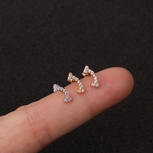 Macro di tre piccoli orecchini a lobo con zirconi in oro, argento e oro rosa