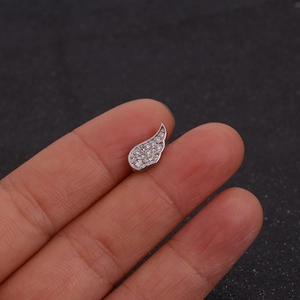 Detalle de piercing de ala en acero inoxidable con circonitas cúbicas engastadas a mano