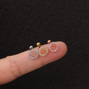 Primer plano macro de pendientes de aro con circonitas en plata, oro y oro rosa
