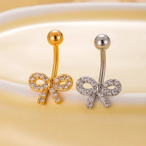 Detail of gold and silver bow belly rings with micro-pave cubic zirconia stones