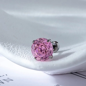 Pink zircon stud earrings in stainless steel with a four-claw setting on ceramic display