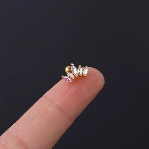 Makroaufnahme eines goldenen Fächer-Ohrsteckers mit AB-Zirkonia auf einer Fingerspitze