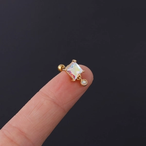 Detailansicht eines Gold-Piercingsteckers mit quadratischem und rundem AB-Zirkon am Finger