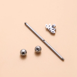 Detailed view of stainless steel industrial barbell components with lucky letter charm