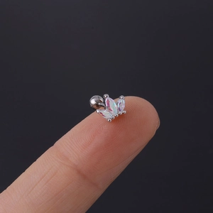 Makro-Detail des kronenförmigen Tragus-Piercings mit schillernden Steinen und Schraubkugel