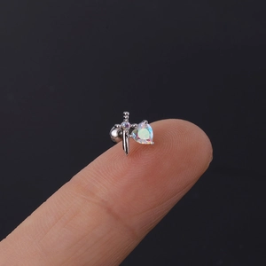 Makroaufnahme von Herz-Opal Schwert-Ohrstecker auf Fingerspitze zeigt die kleine Größe