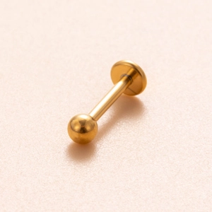 Detailed close-up of a polished gold titanium labret stud with flat back and screw ball