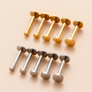 Close-up of gold and silver stainless steel labret studs in five varied lengths