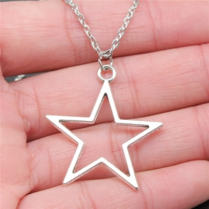 Minimalist silver hollow star pendant necklace held by hand showing actual product size