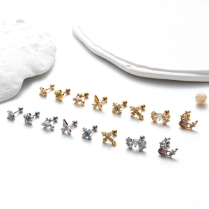 Vue détaillée de clous d'oreilles en acier inoxydable avec motifs papillon et croix
