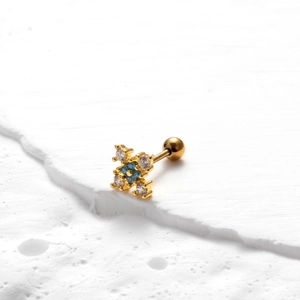 Détail de la boucle d'oreille croix en acier doré avec zircons bleus et blancs