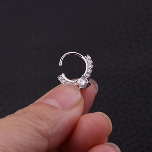 Macro shot of silver nose hoop with tiny paved zircons and a central focal stone