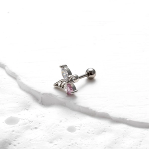 Détail d'un piercing papillon avec gemmes roses et blanches et fermoir à boule