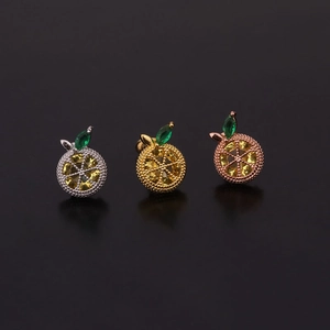 Dettaglio macro di tre orecchini a frutta con zirconi gialli e gemme verdi marquise
