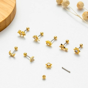 Detailed macro view of gold screw back ear studs with zircon star and moon designs