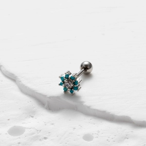 Macro-opname van een sneeuwvlok kraakbeen piercing met blauwe steen en schroefsluiting