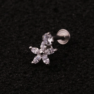 Detail of silver stainless steel labret stud with a zircon flower design on black foam