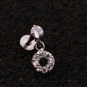 Detailed close-up of a zircon-inlaid stainless steel labret stud with a dangling ring charm