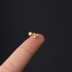 Macro shot of 16G gold-plated stainless steel screw-back stud with three zircon stones