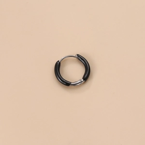 Macro shot of a silver steel hoop earring featuring a glossy black enamel inlay design