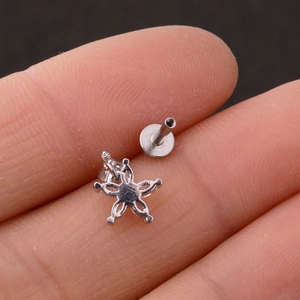 Detailed close-up of a flower-shaped stainless steel stud earring with five zircon stones