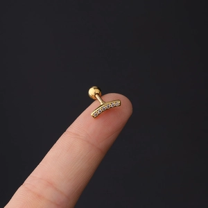 Macro detail of 16G gold curved ear stud with five sparkling cubic zirconia stones