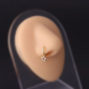 Macro shot of gold nose ring with star pendant and zircon inlays on silicone model