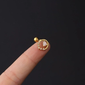 Detailed close-up of a 16G gold cartilage stud with pear-shaped zircon and pave hoop