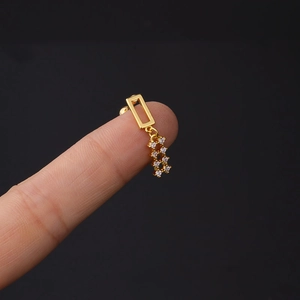 Macro shot of 16G gold-coated stud earring with geometric frame and zircon fringe