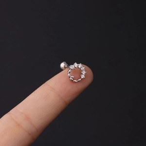 Macro detail of 16G stainless steel cartilage stud with marquise zircon crown on finger