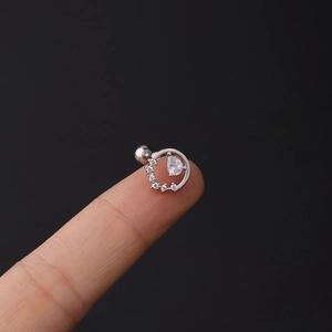 Macro view of pear-cut zircon cartilage stud on fingertip showing precise scale and screw back