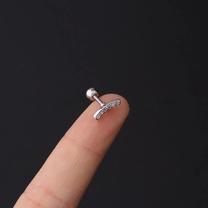 Macro detail of curved 16G stainless steel labret stud with five tiny zircon stones