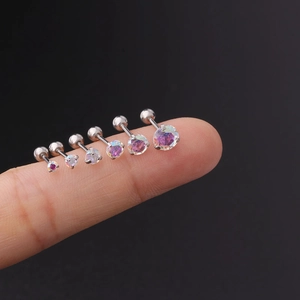 Macro detail of six size variations of AB zircon stainless steel stud earrings on fingertips