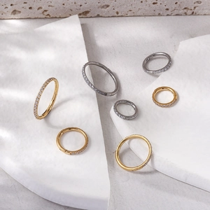 Detailed view of titanium hinged rings with zircon inlay in gold and silver finishes