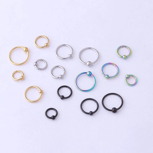 Flat lay of stainless steel captive bead rings in gold, silver, black and rainbow finish