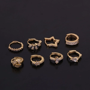 Detailed close-up of 8 gold earring sets with star and zircon inlay on black background
