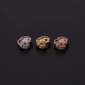 Detail of three hoop earrings in silver, gold, and rose gold with pavé cubic zirconia studs